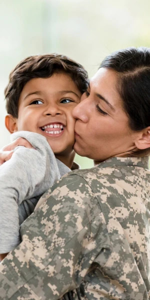 mother in military uniform holding child