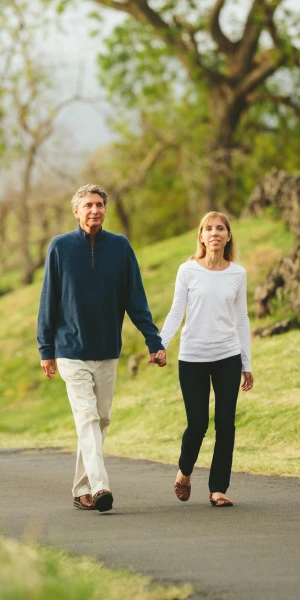 older couple walking in a park holding hands